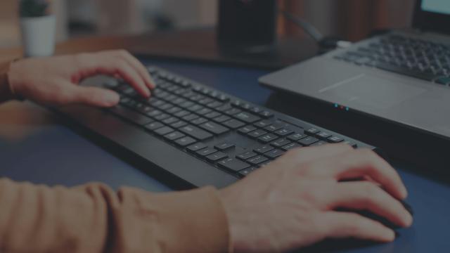 Medarbejder som sidder ved sin arbejdsplads og bruger forskellige HP produkter.